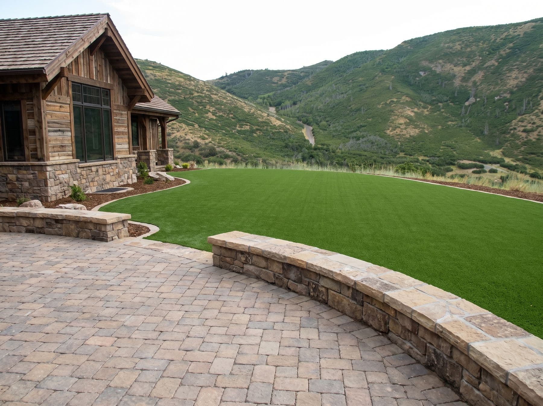 A broad paver terrace with a seat wall opening onto valley views, photographed in a Heber City setting