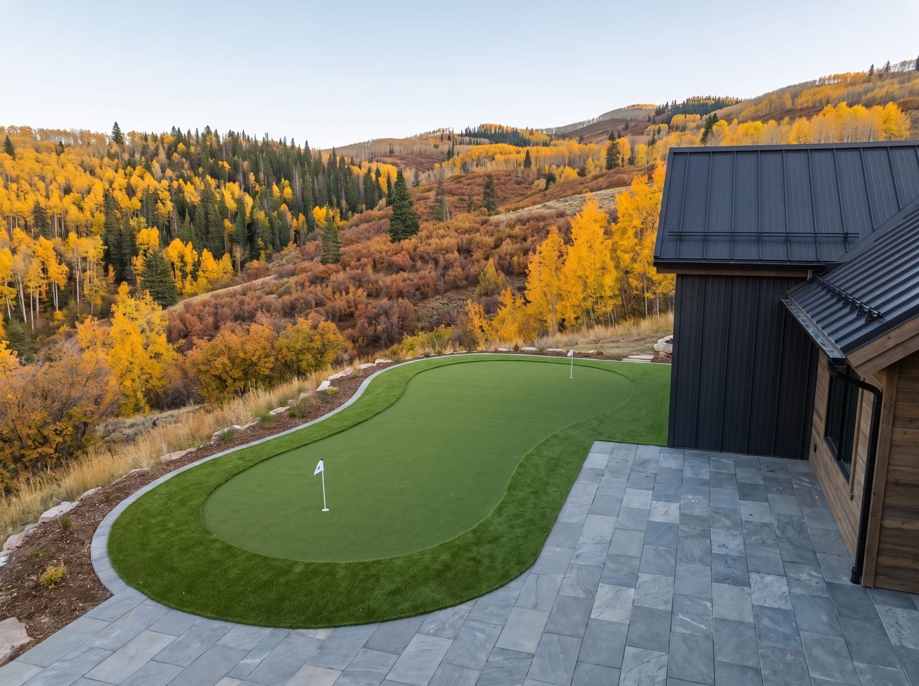 A contoured green and paver terrace at a mountain-modern home, photographed in a Park City setting