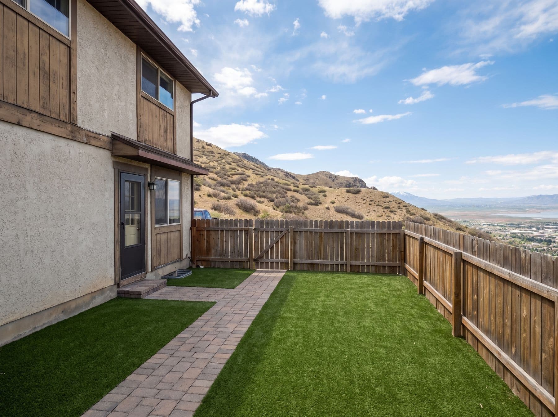 Finished artificial turf and hardscape work photographed in a Utah setting