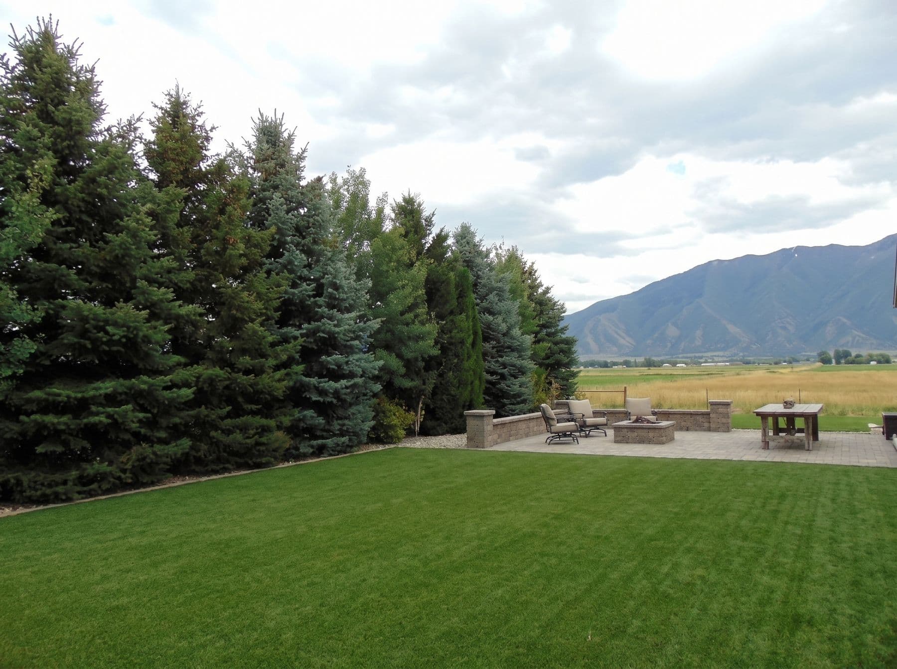 Finished artificial turf and hardscape work photographed in a Utah setting