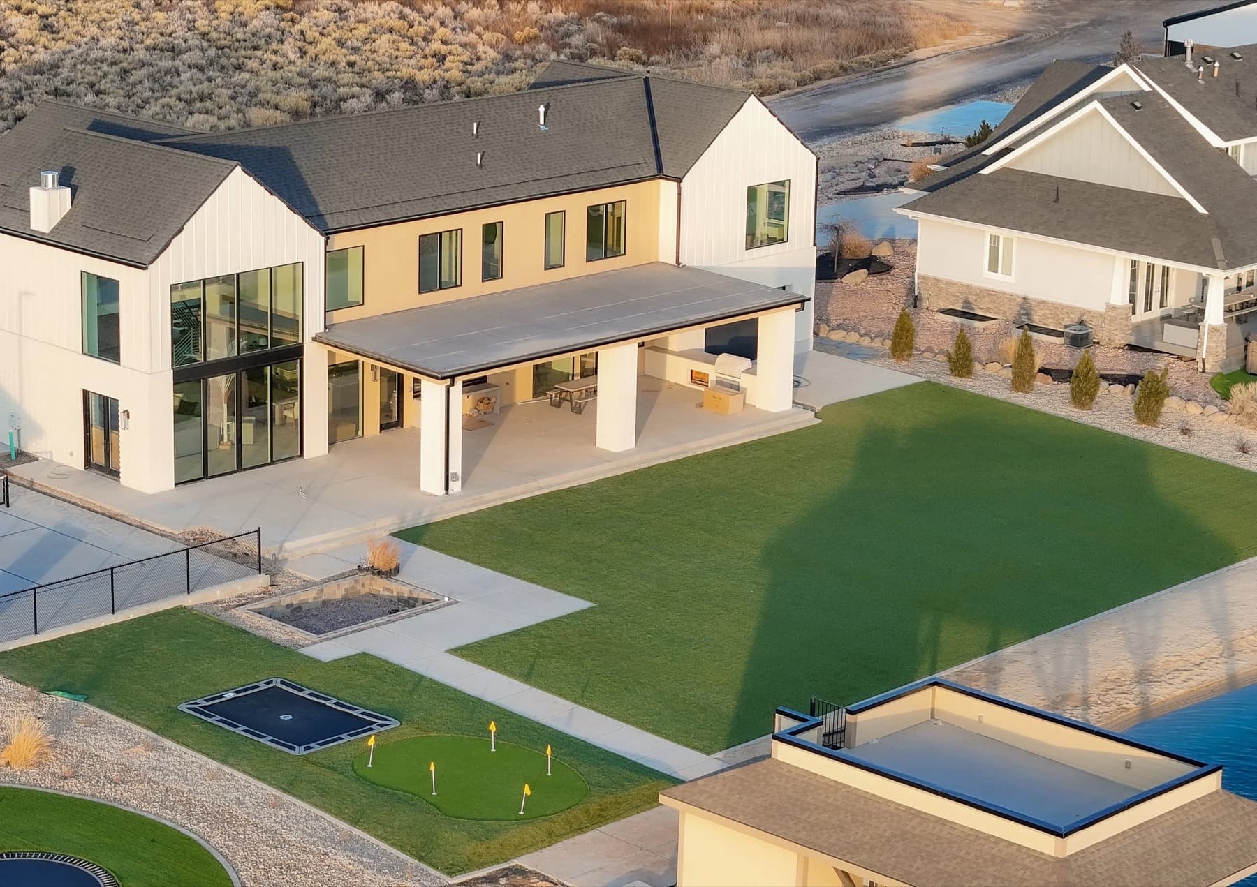 Overhead view of an artificial turf lawn bordered by concrete and planting beds