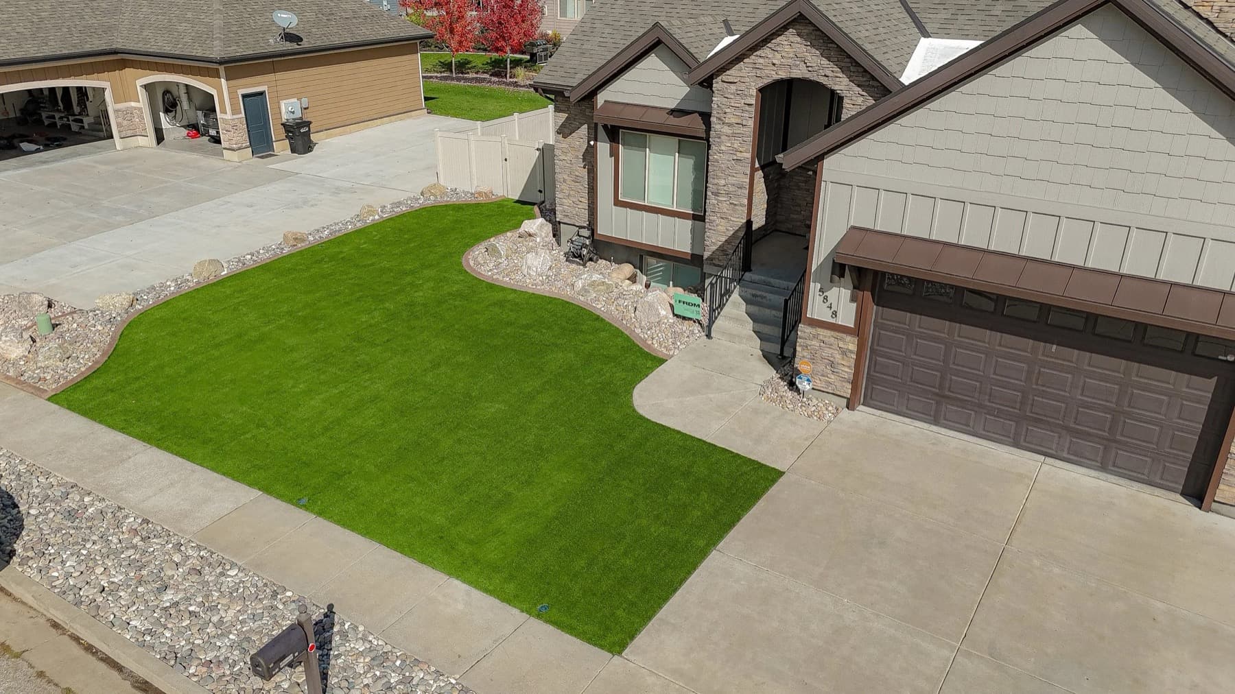 Aerial view of a front yard artificial turf installation with concrete walkways