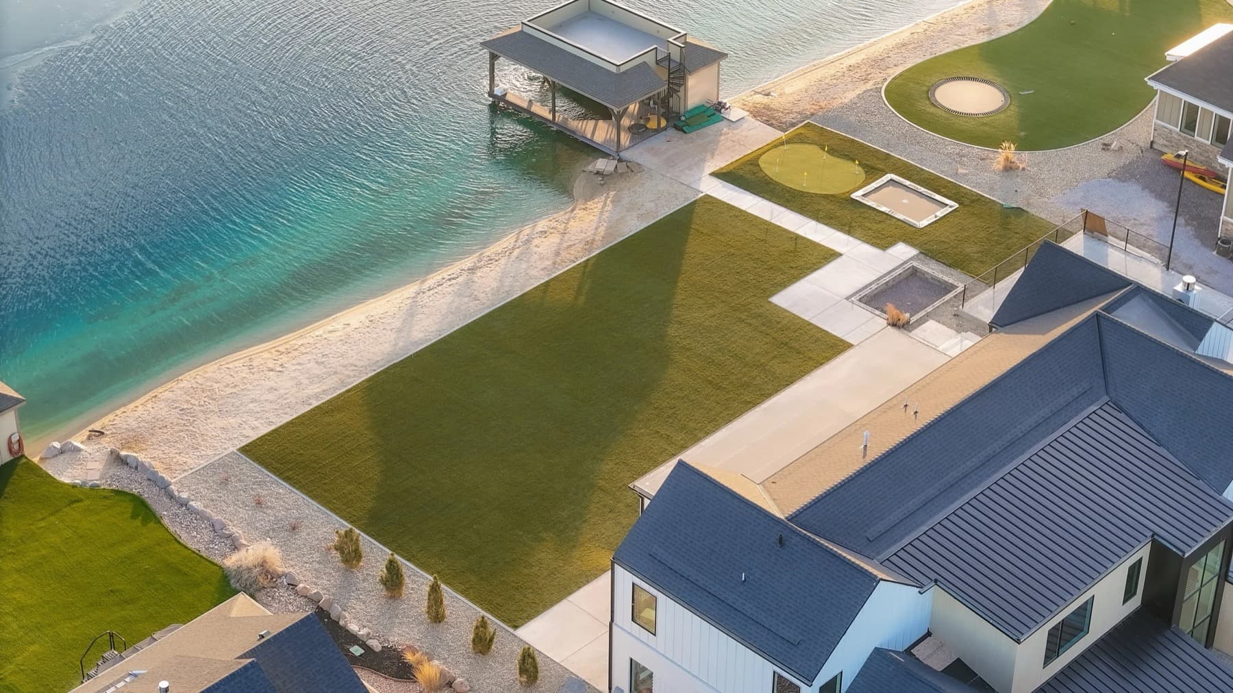 Aerial view of a finished artificial turf backyard with paver patio and clean edge lines