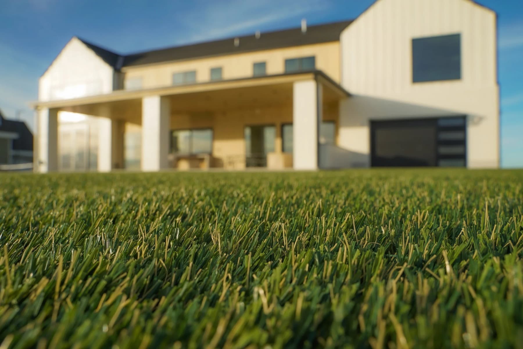 Ground-level view of an installed artificial turf lawn meeting a hard edge